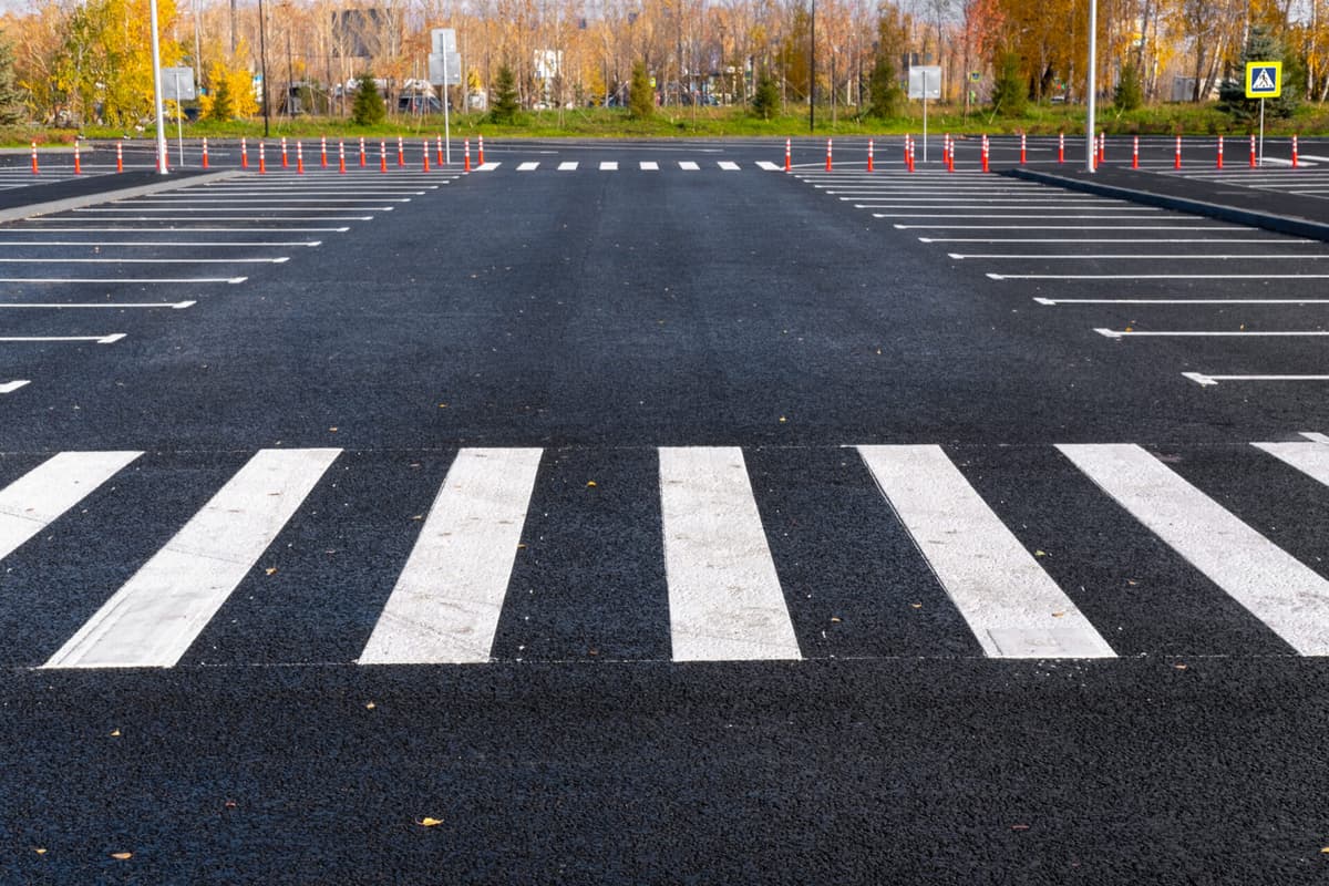 The white and yellow lines of the pedestrian crossing at the intersection of roads in the city. Road safety. Zebra road markings, crossing point of the road, traffic rules